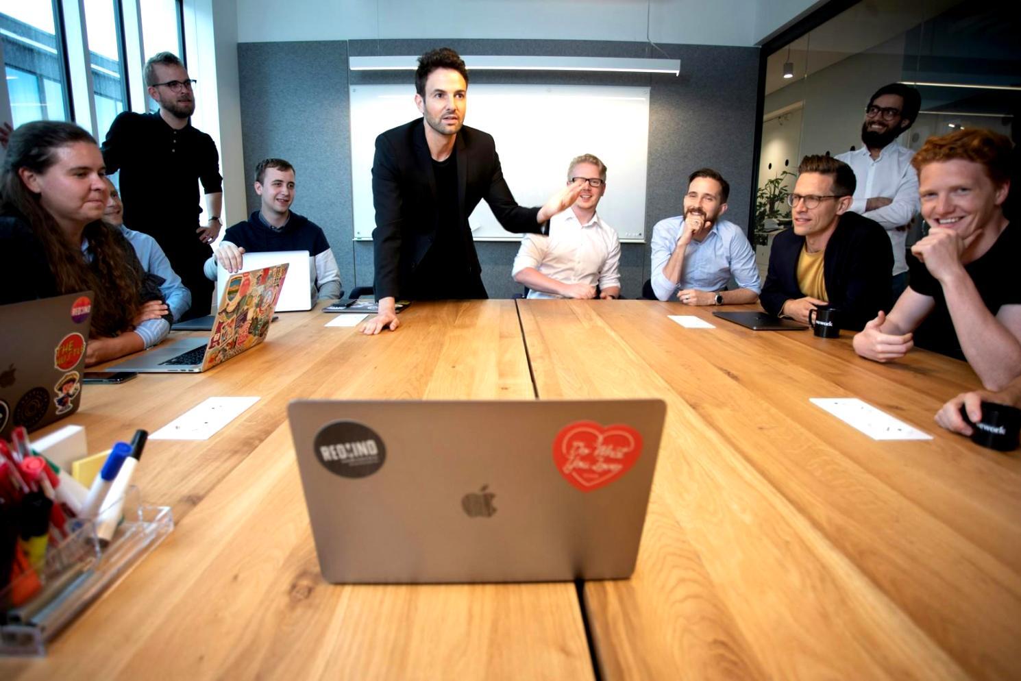 Étudiant travaillant sur un projet de planification financière avec des documents et un ordinateur portable